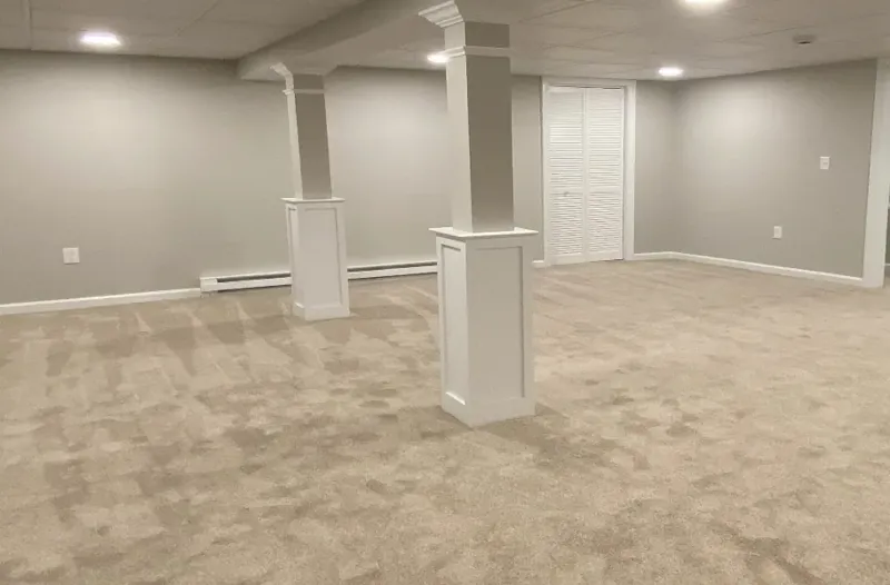 Finished basement in West Hartford, CT with custom paneled columns, recessed lighting and new carpet